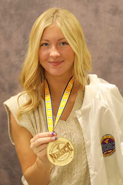 Taylor Brown holding a NHSCC medal and white jacket