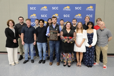 group of Math Club students posing with a plaque