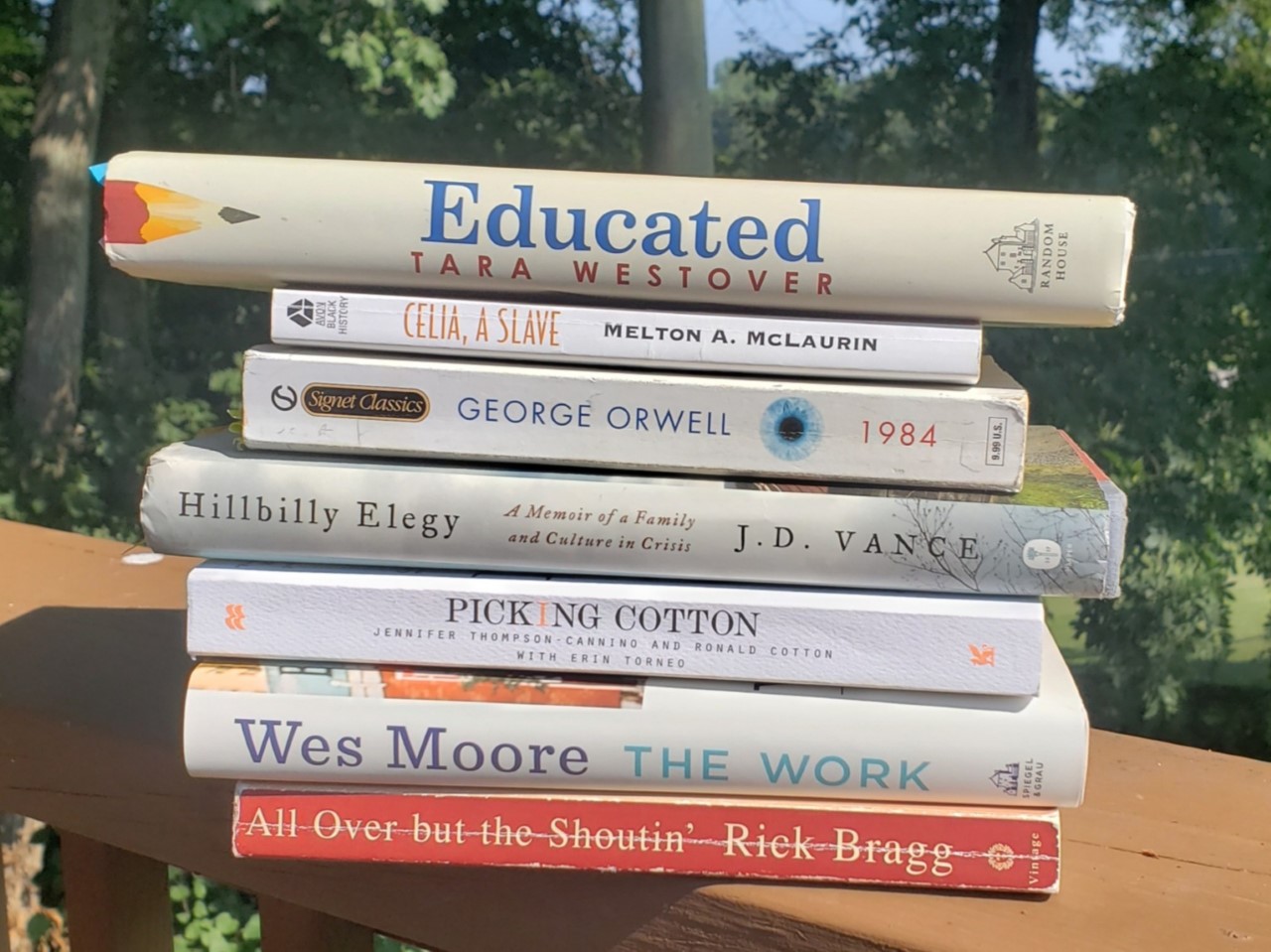 the last seven common read books stacked on a rail