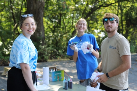 three students in SGA around a table and tie-dying