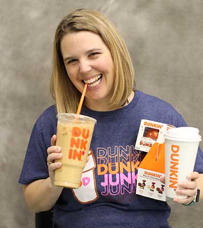 Melissa Chmura holding two coffees from Dunkin Donuts