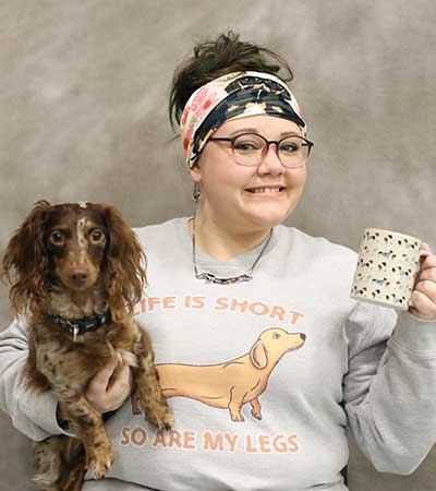 Tawshiana Beggan holding a dog and a coffee cup with dogs on it