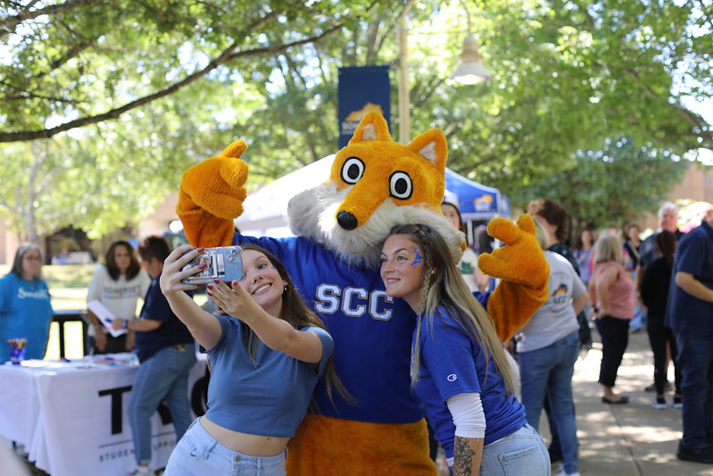 Pathfinder mascot poses with two students taking a selfie