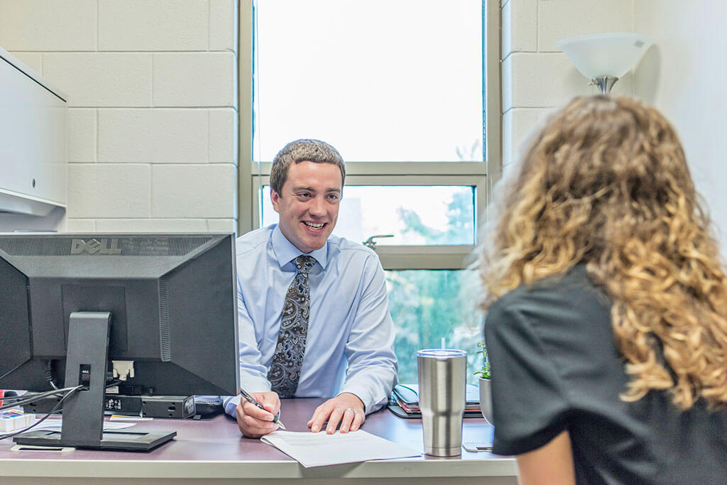 Financial Aid Staff speaking with student in office