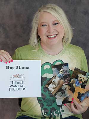 Angie Riley holding images of dogs and a paper that says 'Dog Mom'