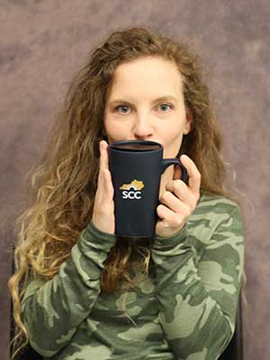 Kaitlyn O’Dell holding a SCC coffee mug