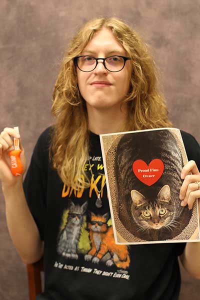 Devon Messer holding a heart and a picture of a cat