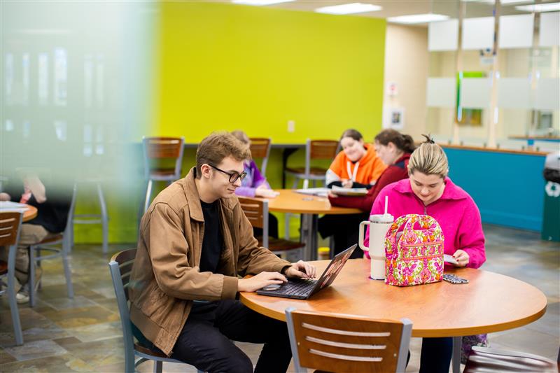 students with laptops sitting at tables