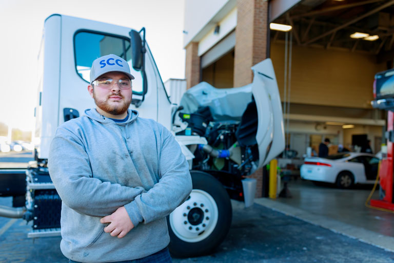 student standing in front of a diesel truck