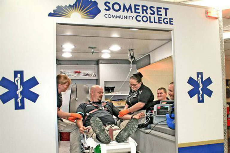 students working in ambulance with patient