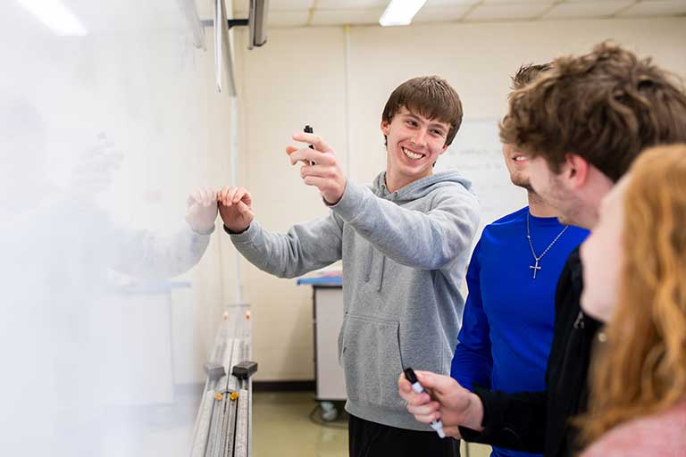 students standing at the white board