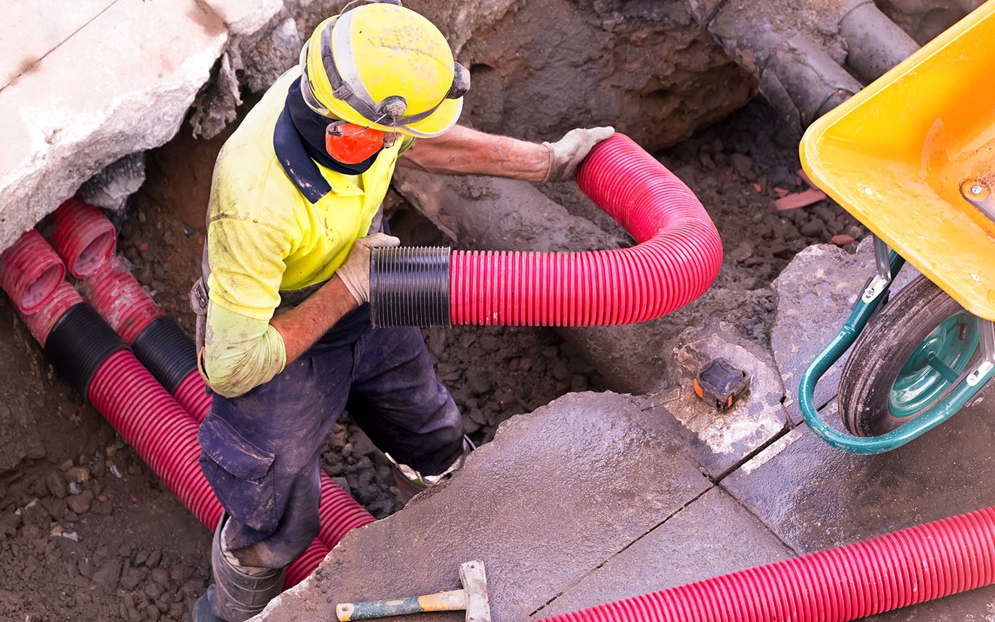 looking down at a man working on an underground pipe