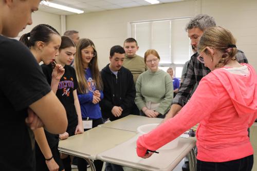 Southern Middle School student trying her hand at a laparoscopic&nbsp;surgery technique with a needle, thread, real surgical tools,&nbsp;and a pink soap loofah.