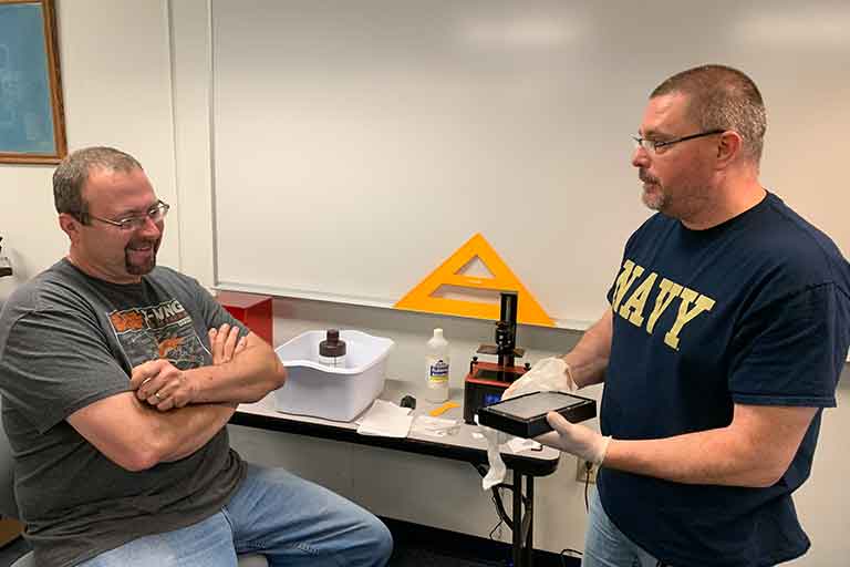 two men discussing a 3d printed object