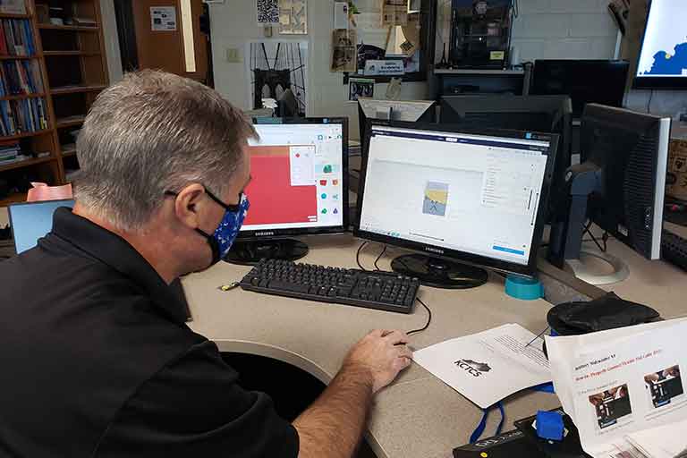 man wearing mask learning to model in 3D at workshop