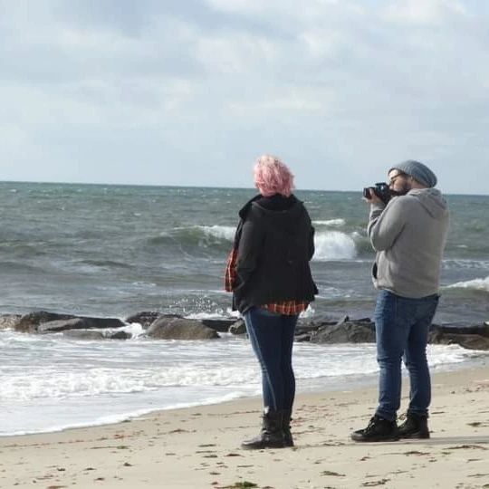 Alvey taking a picture on a beach