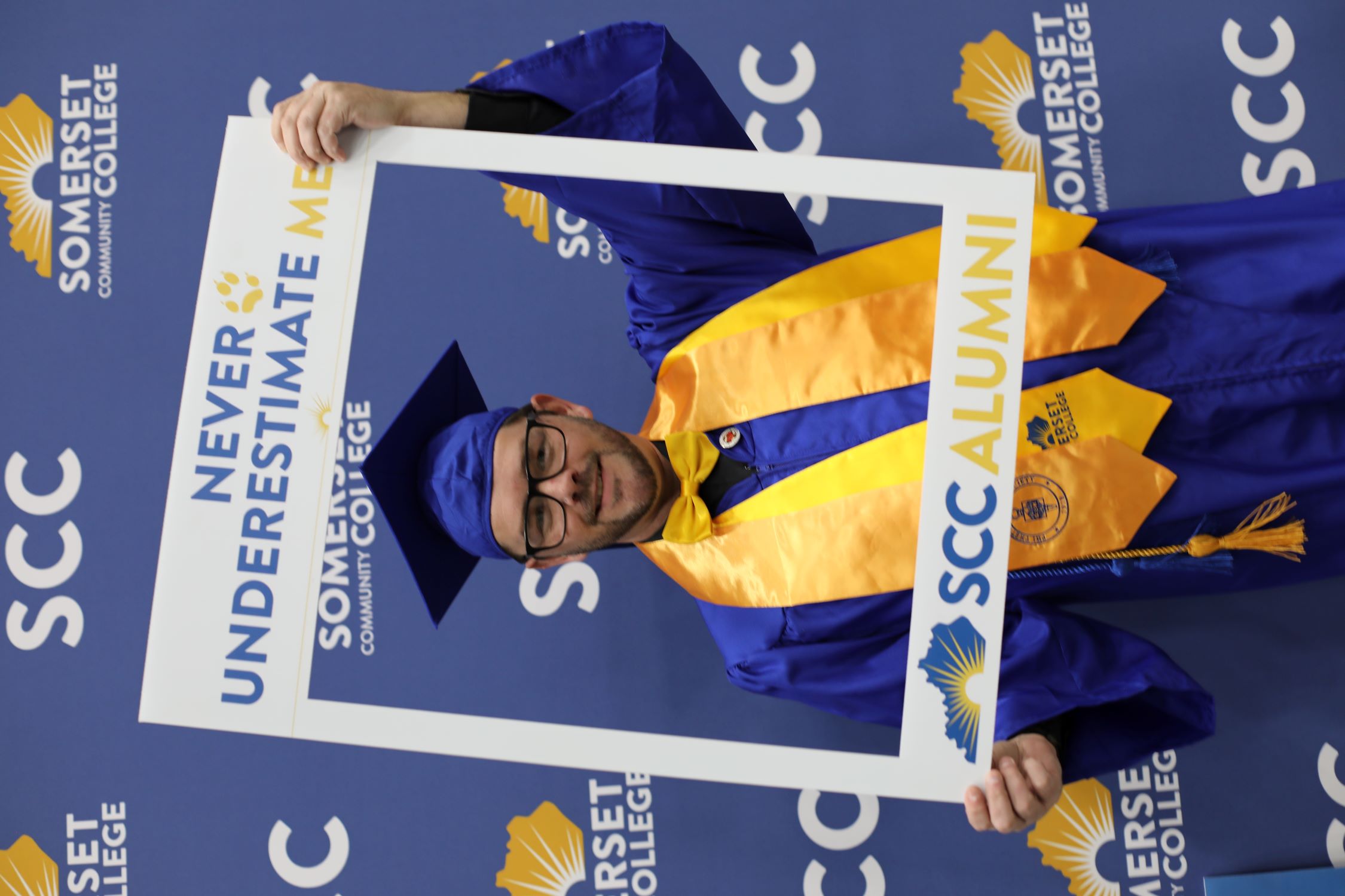 Cody Hurst at graduation holding an SCC photo frame