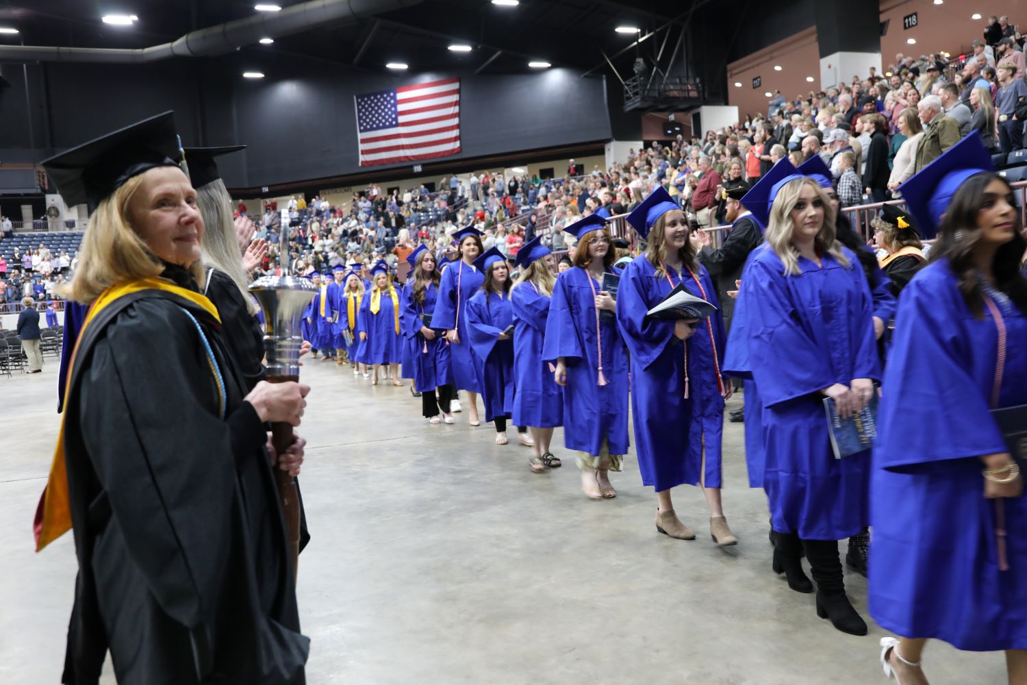 Kathy Lewis holds the maze as student go through the graduation tunnel