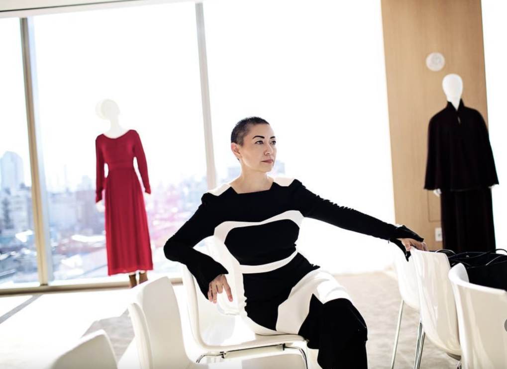 Ane Crabtree sitting with The Handmaid's Tale costumes behind her