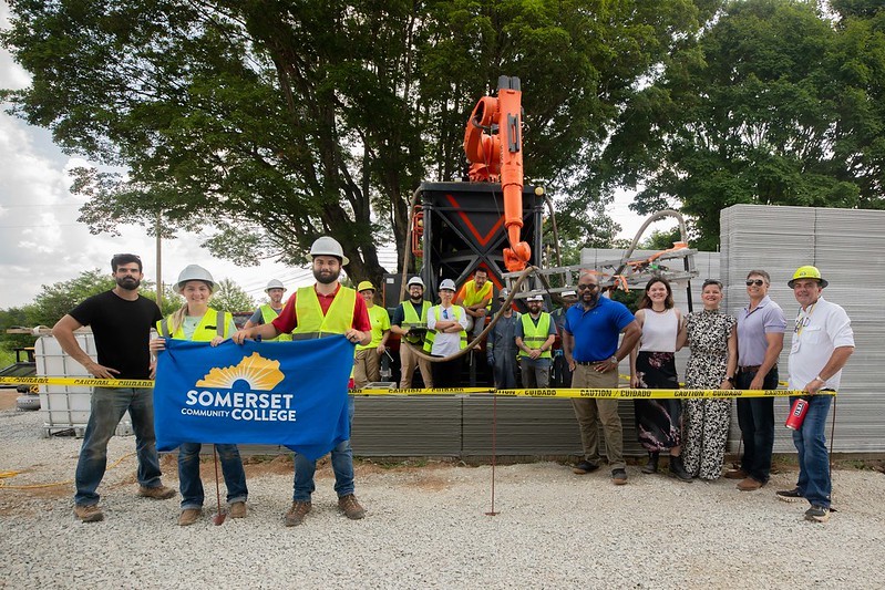 group of construction workers and sponsors at the site of the home being built