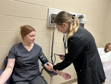 Lockard taking the blood pressure of another student