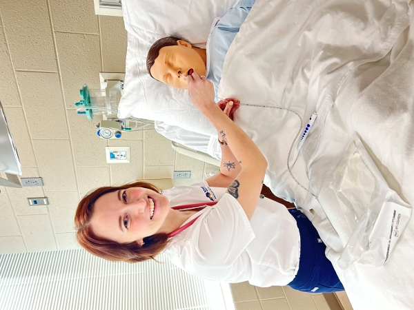 Meade practicing in the nursing lab with a mannequin