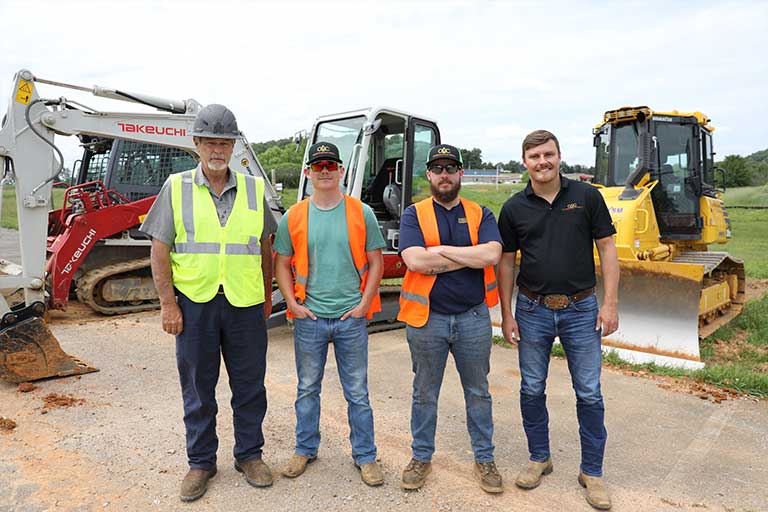 crc sales coordinator poses with students and instructor of the heavy equipment operator program 
