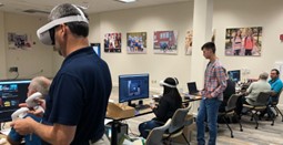 Community College faculty attend a training to learn how to develop their own VR educational modules provided by the Low-cost VR project. Group working on their computers and with VR goggles.