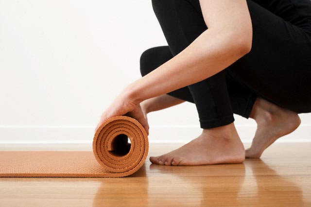 legs of a person rolling up a yoga mat